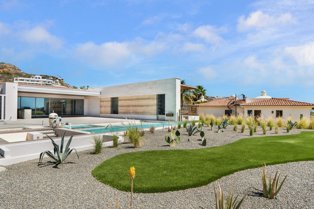 Cabo Golf Villas De Oro Phase 1 Villa de Oro fantastic. Number 304 is very unique as it is one of a few town homes (most are upper or lower)that has a massive dramatic two story window that lights up the home. Downstairs has the impressive living and dining room. The kitchen has a new granite counter, a breakfast area and a bar for guests to enjoy the activity in the kitchen. Outside living with a big space to dine and sit around the large stone fireplace. Upstairs there are two bedroom suites, one of which has an outside terrace to enjoy the ocean for sale