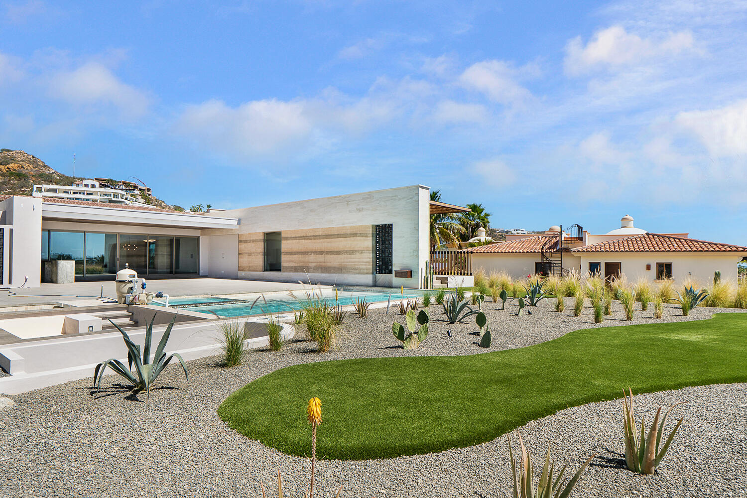 Cabo Golf Villas De Oro Phase 1 Villa de Oro fantastic. Number 304 is very unique as it is one of a few town homes (most are upper or lower)that has a massive dramatic two story window that lights up the home. Downstairs has the impressive living and dining room. The kitchen has a new granite counter, a breakfast area and a bar for guests to enjoy the activity in the kitchen. Outside living with a big space to dine and sit around the large stone fireplace. Upstairs there are two bedroom suites, one of which has an outside terrace to enjoy the ocean for sale