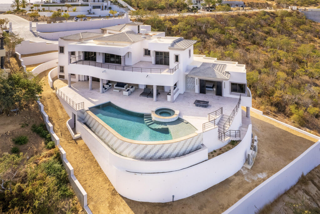 Cabo Golf Villas De Oro Phase 1 Villa de Oro fantastic. Number 304 is very unique as it is one of a few town homes (most are upper or lower)that has a massive dramatic two story window that lights up the home. Downstairs has the impressive living and dining room. The kitchen has a new granite counter, a breakfast area and a bar for guests to enjoy the activity in the kitchen. Outside living with a big space to dine and sit around the large stone fireplace. Upstairs there are two bedroom suites, one of which has an outside terrace to enjoy the ocean for sale
