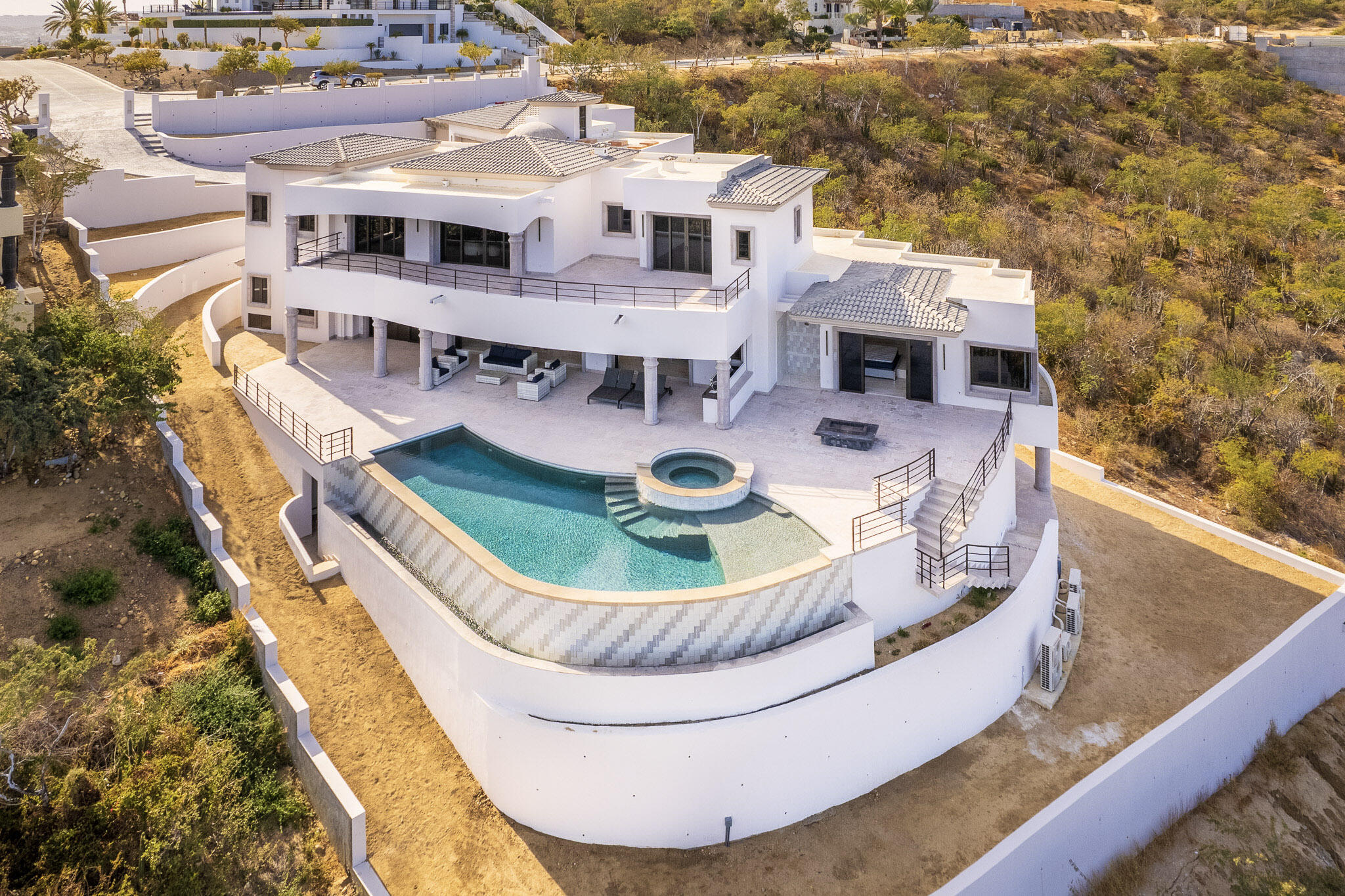 Cabo Golf Villas De Oro Phase 1 Villa de Oro fantastic. Number 304 is very unique as it is one of a few town homes (most are upper or lower)that has a massive dramatic two story window that lights up the home. Downstairs has the impressive living and dining room. The kitchen has a new granite counter, a breakfast area and a bar for guests to enjoy the activity in the kitchen. Outside living with a big space to dine and sit around the large stone fireplace. Upstairs there are two bedroom suites, one of which has an outside terrace to enjoy the ocean for sale