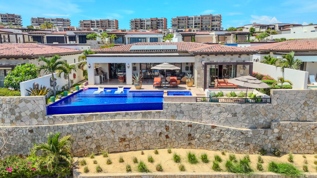 Cabo Golf Villas De Oro Phase 1 Villa de Oro fantastic. Number 304 is very unique as it is one of a few town homes (most are upper or lower)that has a massive dramatic two story window that lights up the home. Downstairs has the impressive living and dining room. The kitchen has a new granite counter, a breakfast area and a bar for guests to enjoy the activity in the kitchen. Outside living with a big space to dine and sit around the large stone fireplace. Upstairs there are two bedroom suites, one of which has an outside terrace to enjoy the ocean for sale