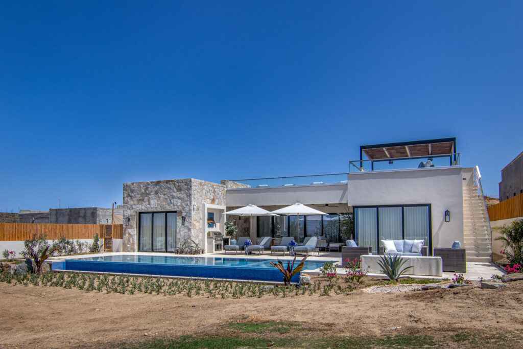 Cabo Golf Villas De Oro Phase 1 Villa de Oro fantastic. Number 304 is very unique as it is one of a few town homes (most are upper or lower)that has a massive dramatic two story window that lights up the home. Downstairs has the impressive living and dining room. The kitchen has a new granite counter, a breakfast area and a bar for guests to enjoy the activity in the kitchen. Outside living with a big space to dine and sit around the large stone fireplace. Upstairs there are two bedroom suites, one of which has an outside terrace to enjoy the ocean for sale